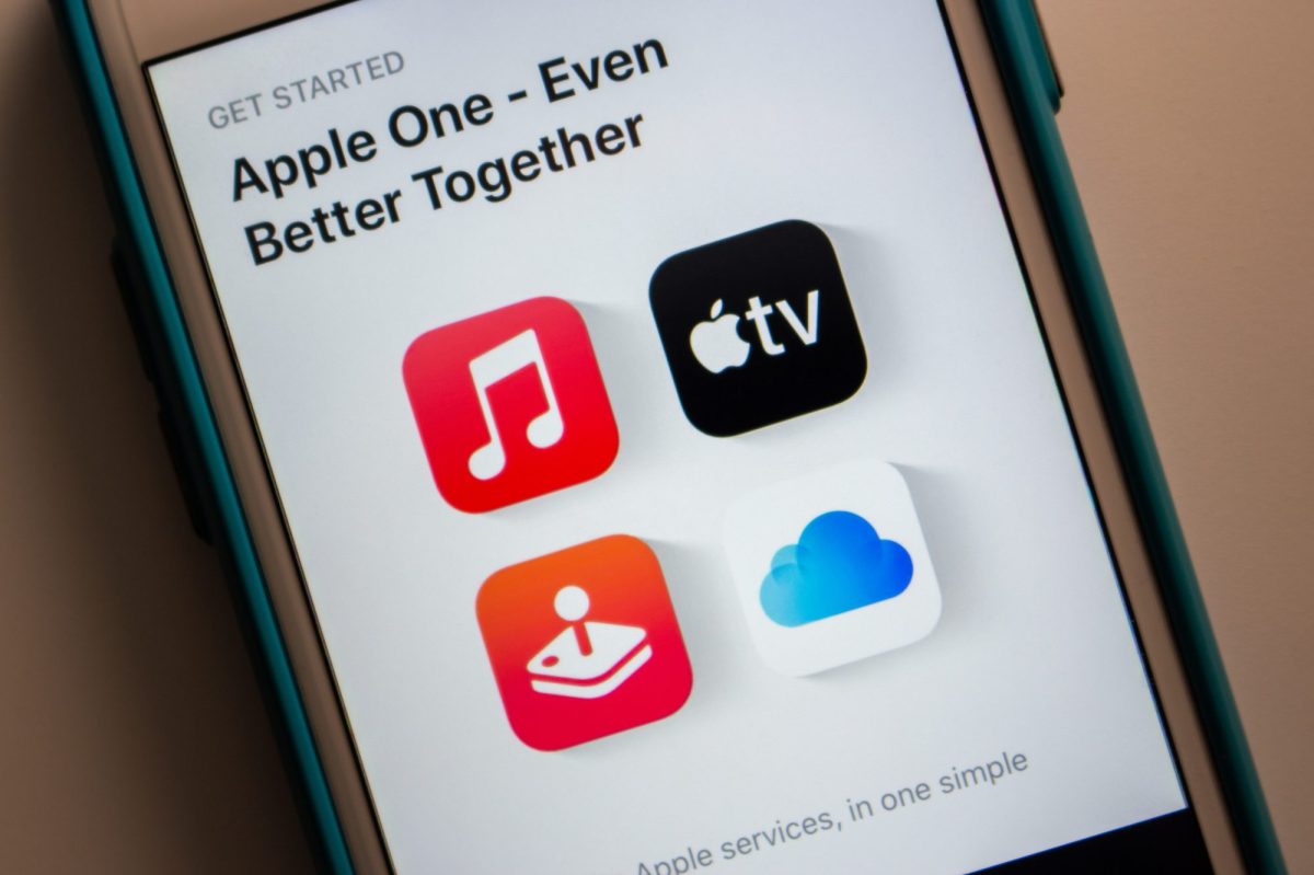 Auf einem Handy-Display werden verschiedene Apple-Dienste angezeigt.