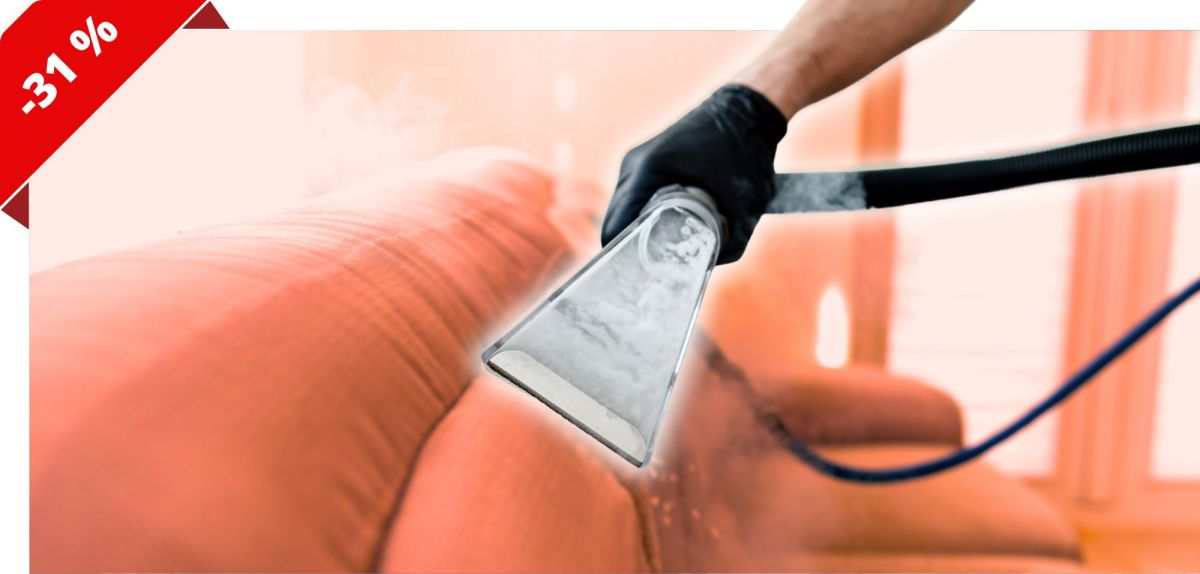Person zieht mit dem Waschsauger ein Sofa ab