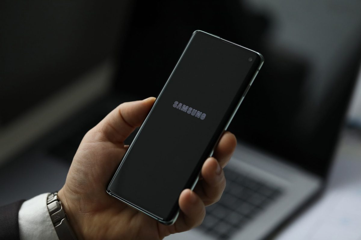 Person hält ein Handy in der Hand. Auf dem Display ist das Samsung-Logo zu sehen.