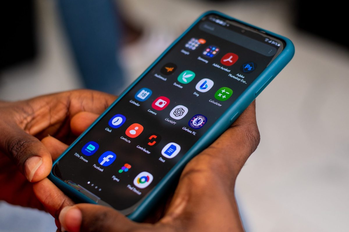 Person hält ein Handy auf dessen Display mehrere Apps angezeigt werden.