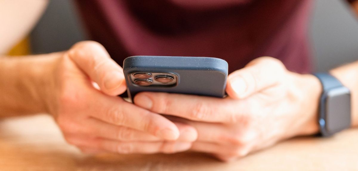 Mann hält iPhone in den Händen