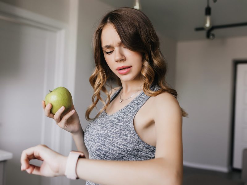 Frau guckt irritiert auf ihre Apple Watch.