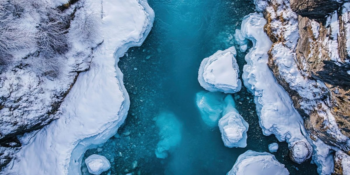 KI-generiertes Bild von Wasser und Schnee in einer Schlucht aus Gestein und Eisbergen.