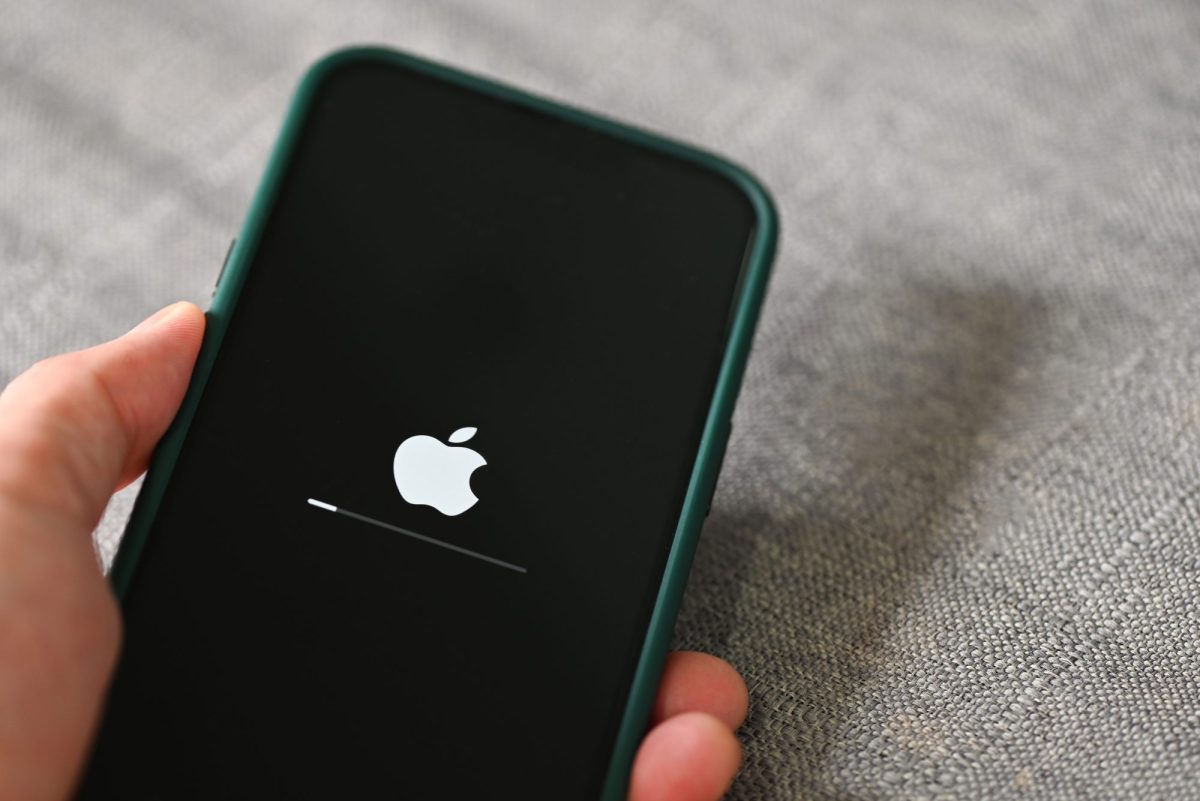 Person hält ein iPhone in der Hand, auf dem gerade ein Update lädt.