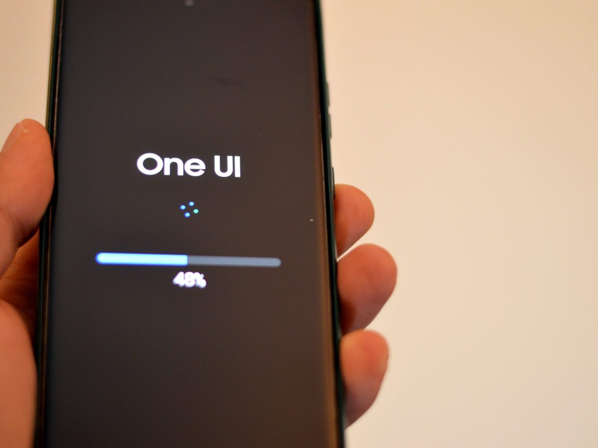 Person hält ein Samsung Galaxy-Handy in der Hand, auf dem eine neue One UI-Version geladen wird. (Symbolbild)