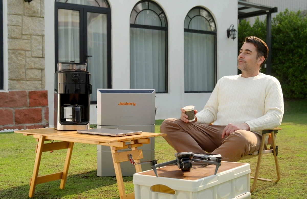 Mann sitzt neben einer Jackery HomePower 2000 Ultra im Garten