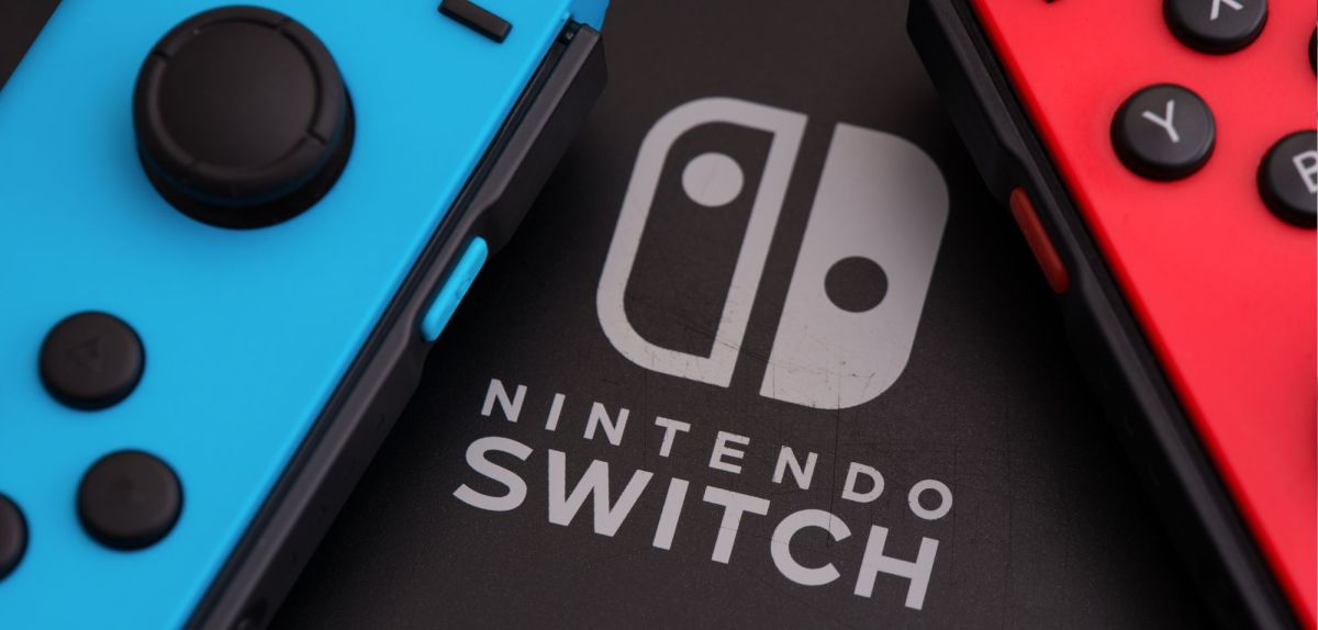 Nintendo-Switch-Logo, links und rechts davon liegen Joy-Cons.