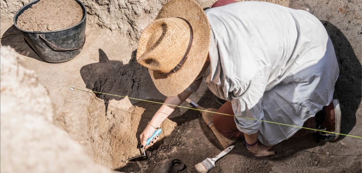 Person gräbt einen archäologischen Fund aus. (Symbolbild)