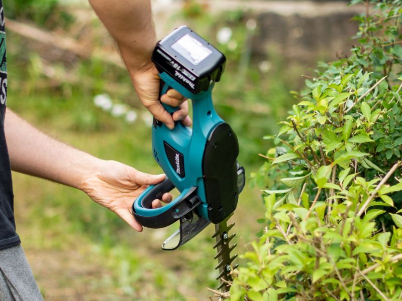 Person hält eine Makita Akku-Heckenschere in der Hand.