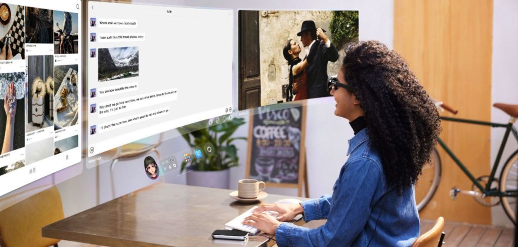 Eine Frau mit Rokid-AR-Brille arbeitet an einer kabellosen Tastatur in einem hellen Café-ähnlichen Umfeld. Vor ihr schweben mehrere große virtuelle Bildschirme mit Chats, Fotos und Videos.